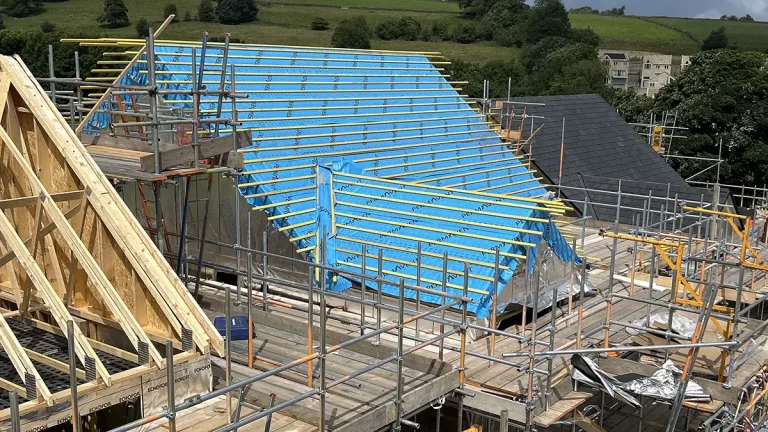 A new build roof surrounded by scaffolding before tiling